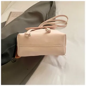 Detail view of pink bucket bag with drawstring and fine stitching on faux leather