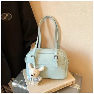 Detail of light blue lychee pattern crossbody bag with a cute plush rabbit pendant