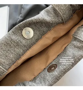 Détail de la fermeture aimantée invisible sur un sac à main en denim gris avec doublure