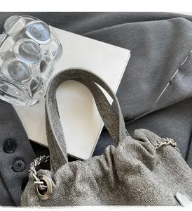 Gros plan détaillé d'un sac à main gris texturé avec chaîne argentée et poignée