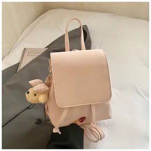 Detailed view of pink PU leather backpack with magnetic flap and cute plush bear charm