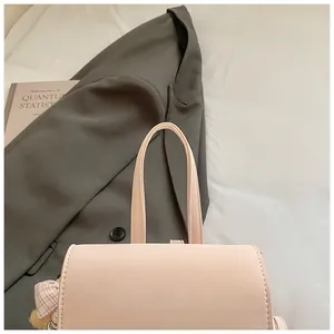 Detail of light pink leather backpack with stitching and pink checkered ornament