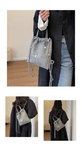 Détails du sac à dos en denim gris avec breloques cœur et bandoulière chaîne