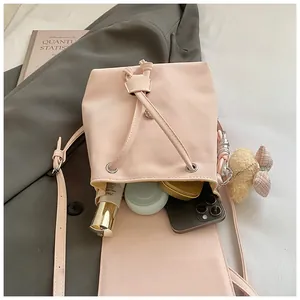 Top view of pink bucket bag capacity with smartphone, makeup, and cute bear charm