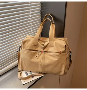 Dettaglio borsa da viaggio in tela kaki con tasche a zip e tracolla regolabile