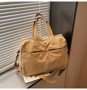 Dettaglio borsa da viaggio kaki con trama in tela resistente e cuciture rosse di rinforzo