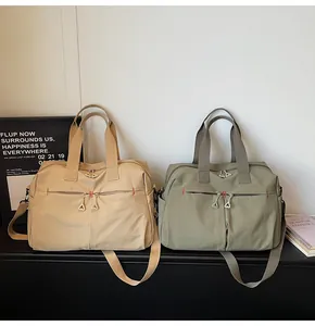 Dettaglio di borse da viaggio in tela beige e verde con doppie tasche frontali con cerniera