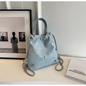 Détail du sac en denim bleu clair avec sequins cœur argentés et bandoulière chaîne