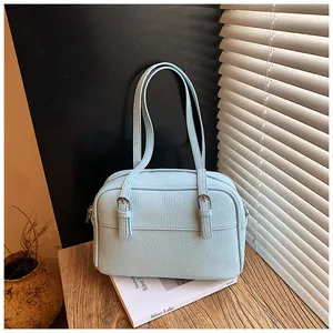 Close-up of light blue lychee pattern leather bag with silver buckle and thin straps