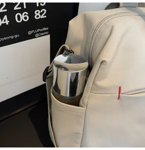 Dettaglio della tasca laterale della borsa da viaggio in tela beige con borraccia