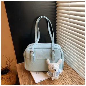 Macro shot of light blue litchi pattern handbag with cute plush rabbit charm