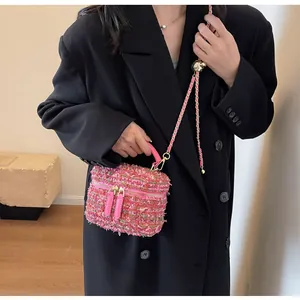 Detailansicht der rosa Tweed-Box-Tasche mit Goldkette und Ledergriff an einem Model