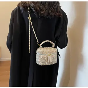 Detailansicht eines Modells mit champagnerfarbener Tweed-Box-Tasche und Kettenriemen