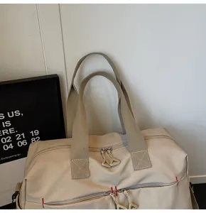 Dettaglio borsa da viaggio in tela bianco avorio con cuciture rosse e zip resistente