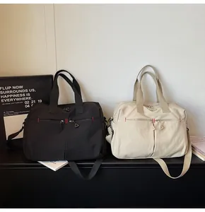 Dettaglio di borse da viaggio in tela nera e beige con manici e cerniere resistenti