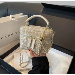 Makro-Detail der schicken Tweed-Handtasche mit Goldkette und funkelnden Pailletten