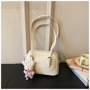 Detail of cream lychee leather shoulder bag with adjustable strap and cute rabbit pendant
