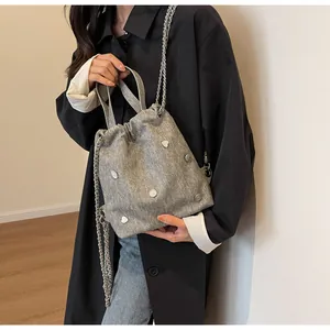 Sac seau en tweed gris avec cœurs blancs et chaîne argentée porté en bandoulière