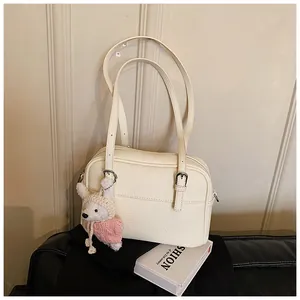 Close-up of cream lychee pattern leather shoulder bag with a cute rabbit doll charm