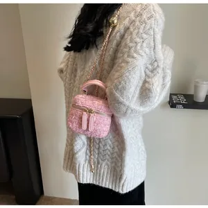 Detail der rosa Tweed-Beuteltasche mit goldener Kette und Ledergriff für Damen