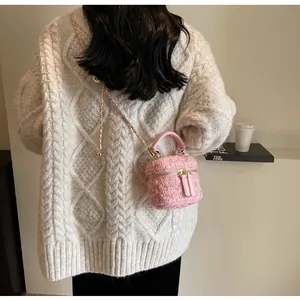 Rosa Tweed-Beuteltasche getragen als Umhängetasche mit Kettenriemen und feiner Webstruktur