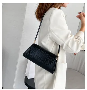 Detail der schwarzen Krokodilleder-Struktur und Goldbeschläge dieser eleganten Damen-Handtasche