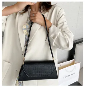 Nahaufnahme der schwarzen baguette-tasche mit krokodilmuster, minimalistisch getragen