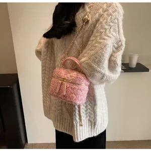 Detailansicht der rosa Tweed-Minitasche mit goldener Kette und verstellbarem Goldball