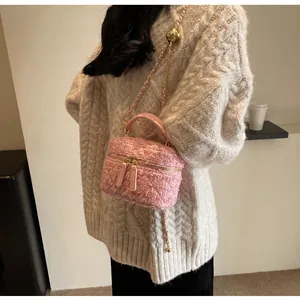 Detail der rosa Tweed-Tasche mit verstellbarer Goldkugel-Kette und Handgriff