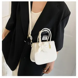 Dettaglio borsa bianca texture litchi con manico in seta e scritte fashion laterali
