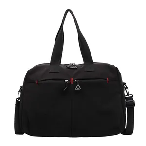 Large black water-resistant sports travel bag with red stitching and adjustable strap