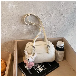 Detail of off-white lychee texture bag with silver zipper and cute plush bear charm