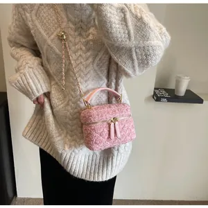 Detailansicht der pinkfarbenen Tweed-Handtasche mit goldener Kette und Kugelverschluss