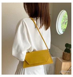 Schicke gelbe Krokodilmuster Umschlagtasche in minimalistischer Lifestyle-Umgebung