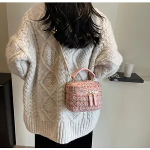 Detailansicht der rosa Tweed-Minitasche mit goldener Kette und Doppelreißverschluss