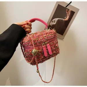 Nahaufnahme der rosa Tweed-Mini-Eimertasche mit goldener Kette und Ledergriff-Detail