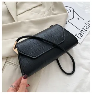 Detailansicht der schwarzen Schultertasche mit Krokodilmuster und goldener Hardware