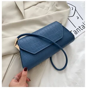 Detailansicht der dunkelblauen Schultertasche mit Krokodilleder-Prägung und goldener Schnalle