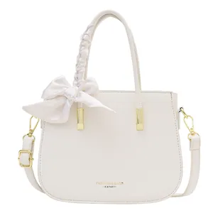 Elegante borsa a mano in pelle color crema con fiocco e tracolla regolabile