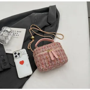 Nahaufnahme der rosa Tweed-Handtasche mit goldener Kette und elegantem Tragegriff