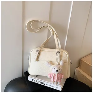 Detail of lychee pattern cream leather bag with a cute plush rabbit charm