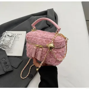 Detailansicht der rosa Tweed-Textur mit Doppelreißverschluss und Goldkugelkette
