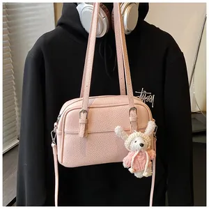 Pink lychee texture crossbody bag with adjustable strap and cute knit rabbit charm