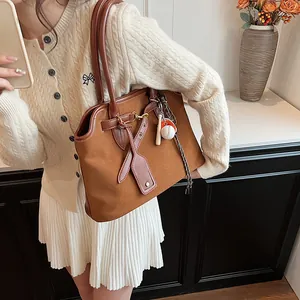 Brown suede tote bag with leather straps and baseball charm for professional women
