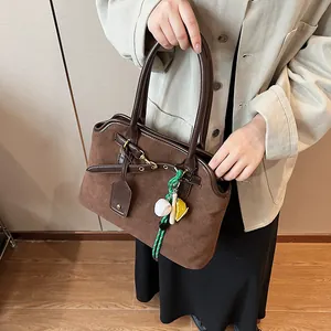 Vintage brown suede shoulder bag for women with leather trim and decorative bag charms