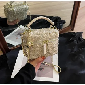 Detailansicht der beigefarbenen Tweed-Kosmetiktasche mit Pailletten und Goldkette