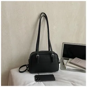 Close-up of black litchi pattern leather bag with silver hardware and dual handles