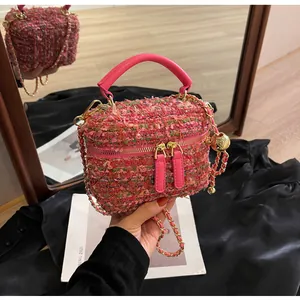 Details der rosa Tweed-Handtasche mit goldener Kette und eleganter Metallstruktur