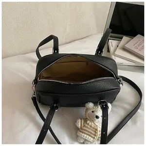 Detailed top view of black lychee grain leather handbag with spacious zipper interior