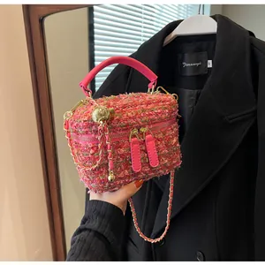 Detail der rosa Tweed-Handtasche mit goldenen Reißverschlüssen und eleganter Metallkette